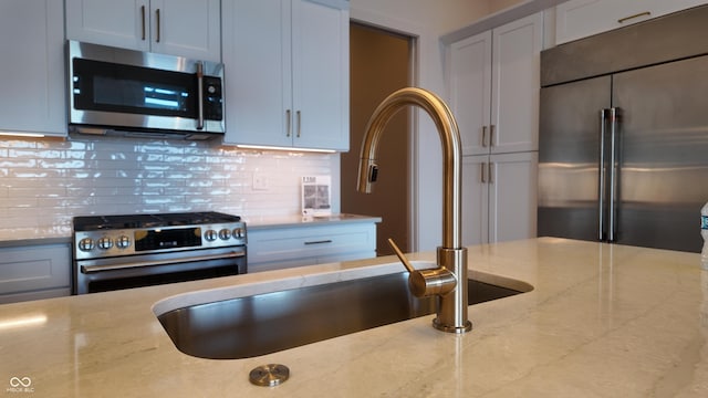 925 Veterans Way Unit 101, Carmel, IN 46032 - kitchen with stainless steel appliances, light stone counters, and backsplash