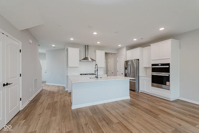 9751 Behner Dr, Fishers, IN 46250 - kitchen featuring stainless steel refrigerator with ice dispenser, wall chimney exhaust hood, double oven, light wood-style floors, and tasteful backsplash