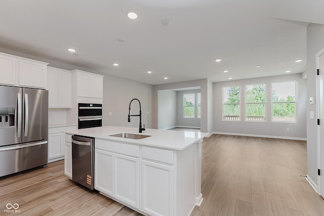 9751 Behner Dr, Fishers, IN 46250 - kitchen featuring stainless steel appliances, a center island with sink, light wood finished floors, recessed lighting, and light countertops
