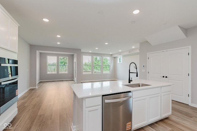 9751 Behner Dr, Fishers, IN 46250 - kitchen with stainless steel dishwasher, recessed lighting, open floor plan, light wood finished floors, and an island with sink