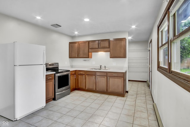 168 Midway Ct S, Hope, IN 47246 - kitchen featuring freestanding refrigerator, electric range, light countertops, brown cabinets, and recessed lighting