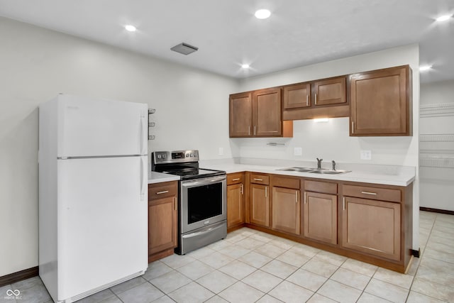 168 Midway Ct S, Hope, IN 47246 - kitchen featuring freestanding refrigerator, stainless steel electric range, light countertops, brown cabinetry, and recessed lighting
