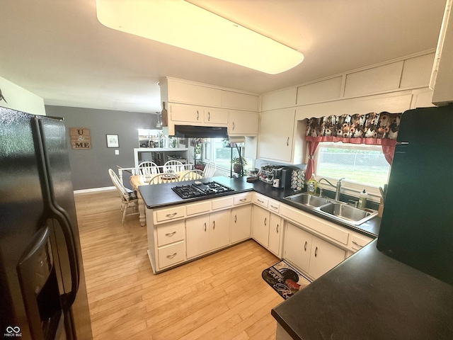 2615 Alexandria Pike, Anderson, IN 46012 - kitchen featuring refrigerator with ice dispenser, stainless steel gas cooktop, a peninsula, light wood-style flooring, and under cabinet range hood