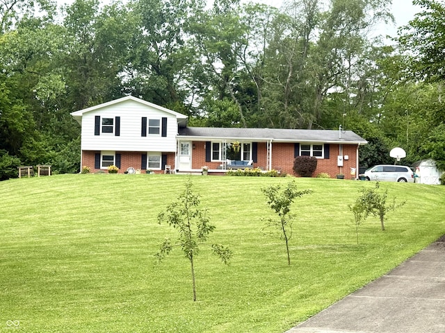 2615 Alexandria Pike, Anderson, IN 46012 - split level home with brick siding, a front yard, and view of wooded area