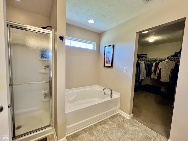 13859 Keams Dr, Fishers, IN 46038 - bathroom featuring a shower stall, a garden tub, a walk in closet, and a textured ceiling