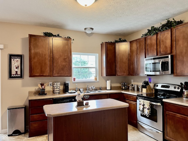 13859 Keams Dr, Fishers, IN 46038 - kitchen featuring appliances with stainless steel finishes, light countertops, a center island, and a textured ceiling