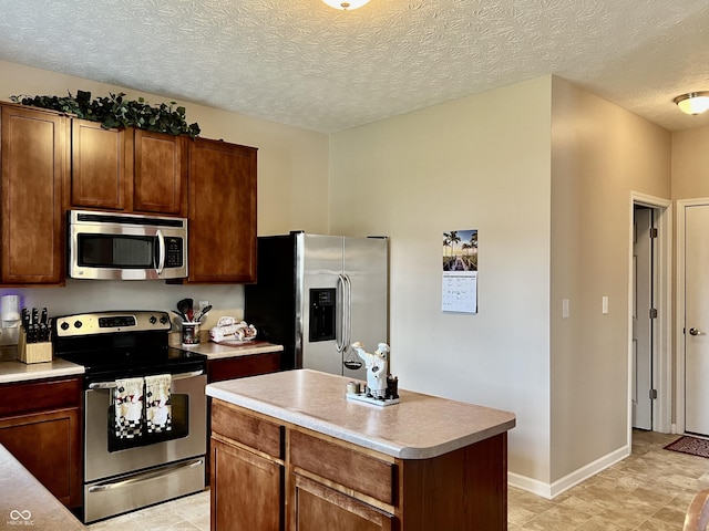 13859 Keams Dr, Fishers, IN 46038 - kitchen featuring stainless steel appliances, light countertops, a kitchen island, and a textured ceiling
