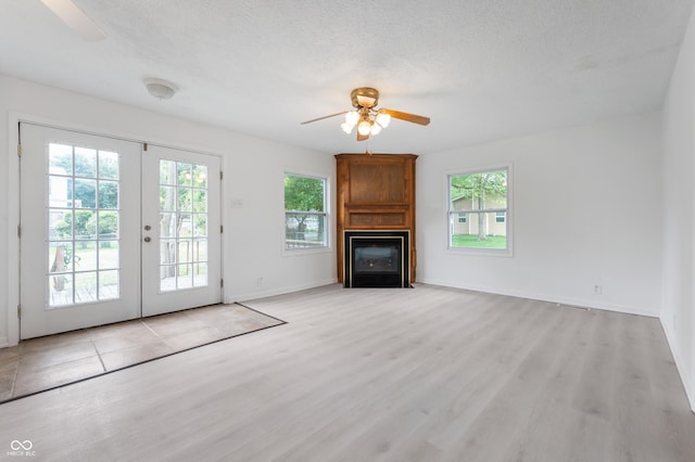 321 W Broad St, Spiceland, IN 47385 - unfurnished living room featuring ceiling fan, healthy amount of natural light, a large fireplace, light wood-style flooring, and a textured ceiling