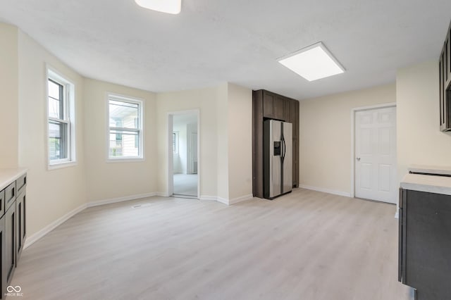 321 W Broad St, Spiceland, IN 47385 - kitchen with stainless steel fridge with ice dispenser, light wood-style flooring, light countertops, and dark brown cabinetry