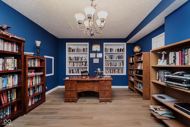 11074 Galley Way, Fishers, IN 46040 - office area featuring a chandelier, light wood-style floors, a textured ceiling, bookshelves, and built in shelves