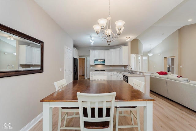 11074 Galley Way, Fishers, IN 46040 - kitchen featuring stainless steel microwave, light wood-style floors, a chandelier, a peninsula, and white cabinets
