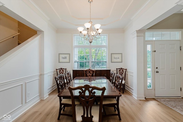11074 Galley Way, Fishers, IN 46040 - dining space featuring light wood finished floors, a chandelier, a decorative wall, a tray ceiling, and ornamental molding