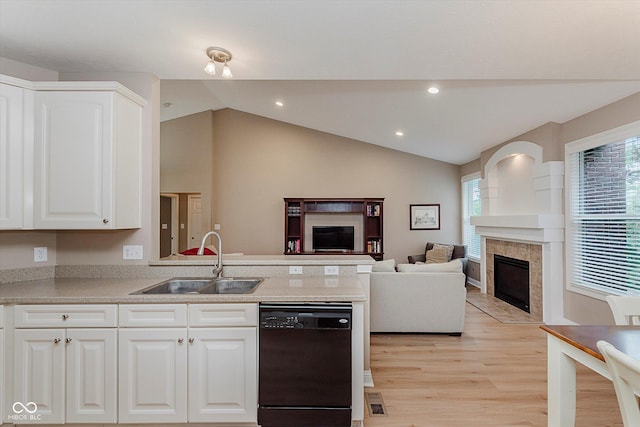 11074 Galley Way, Fishers, IN 46040 - kitchen featuring a fireplace, black dishwasher, light wood-style floors, a peninsula, and lofted ceiling