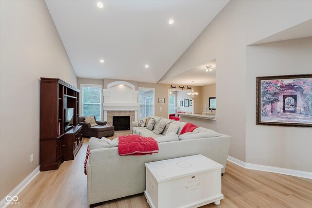 11074 Galley Way, Fishers, IN 46040 - living area with light wood-style floors, recessed lighting, a fireplace, a chandelier, and high vaulted ceiling