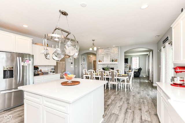 9053 Fitzgerald Dr, Indianapolis, IN 46239 - kitchen with stainless steel fridge, arched walkways, light countertops, light wood-style floors, and recessed lighting