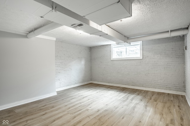 4904 N Washington Blvd, Indianapolis, IN 46205 - basement with brick wall, a textured ceiling, and light wood-style floors