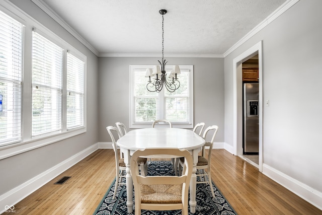 4904 N Washington Blvd, Indianapolis, IN 46205 - dining space featuring a chandelier, light wood-type flooring, ornamental molding, and a textured ceiling