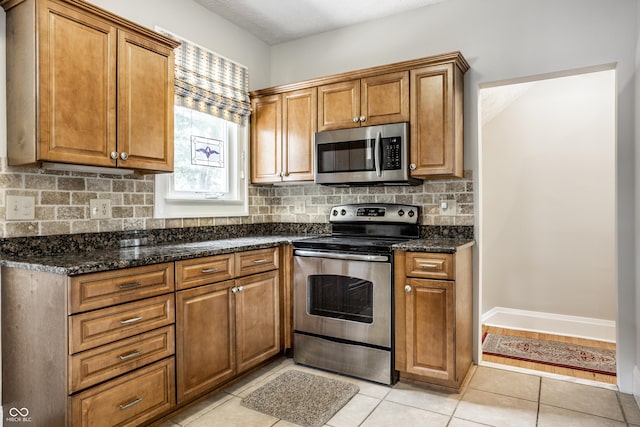 4904 N Washington Blvd, Indianapolis, IN 46205 - kitchen featuring appliances with stainless steel finishes, brown cabinets, decorative backsplash, and light tile patterned floors