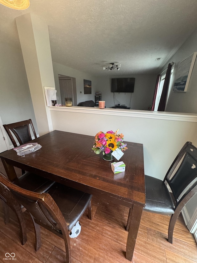 6027 Moonseed Cir, Indianapolis, IN 46203 - dining room featuring wood finished floors and a textured ceiling