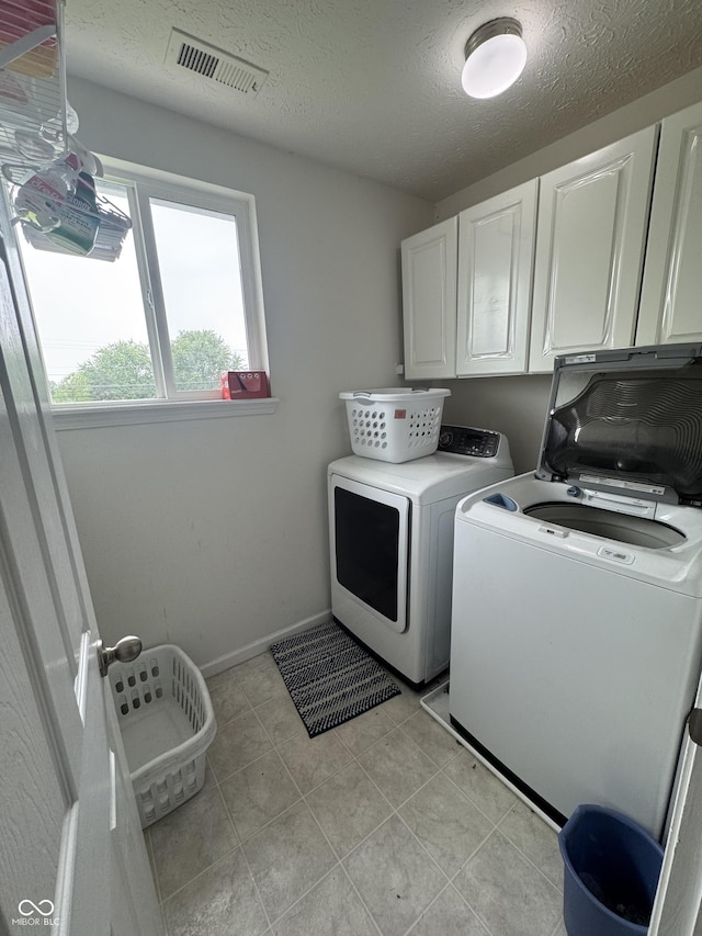 6027 Moonseed Cir, Indianapolis, IN 46203 - washroom featuring cabinet space, washing machine and clothes dryer, and a textured ceiling