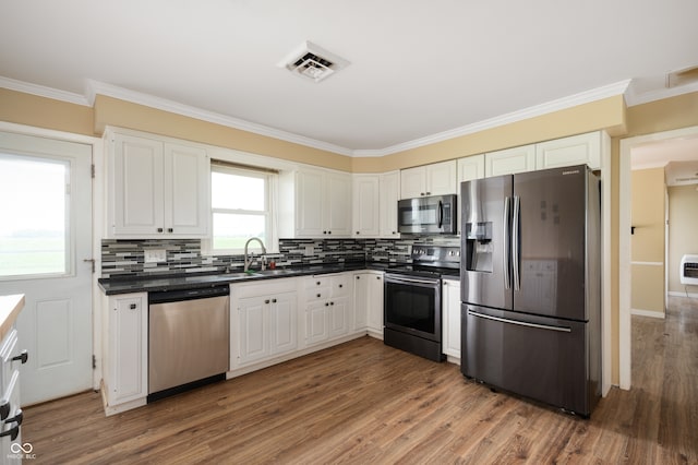 10500 S County Road 200 W, Muncie, IN 47302 - kitchen with appliances with stainless steel finishes, dark countertops, ornamental molding, wood finished floors, and tasteful backsplash