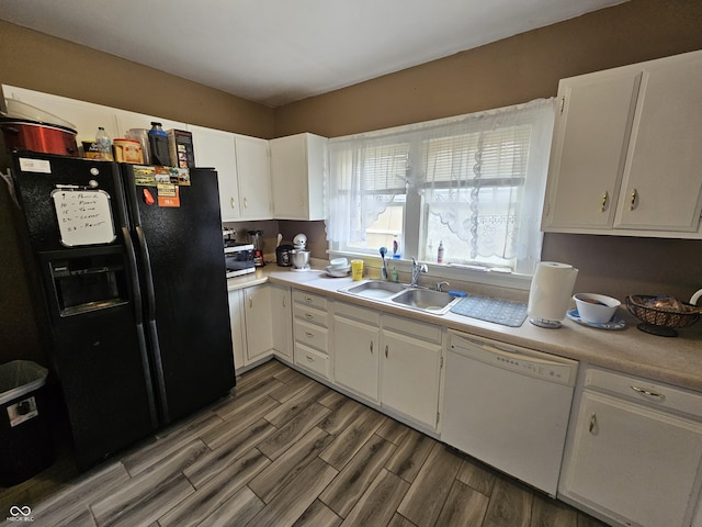 2824 Brown St, Anderson, IN 46016 - kitchen with black fridge, dishwasher, light countertops, and white cabinets