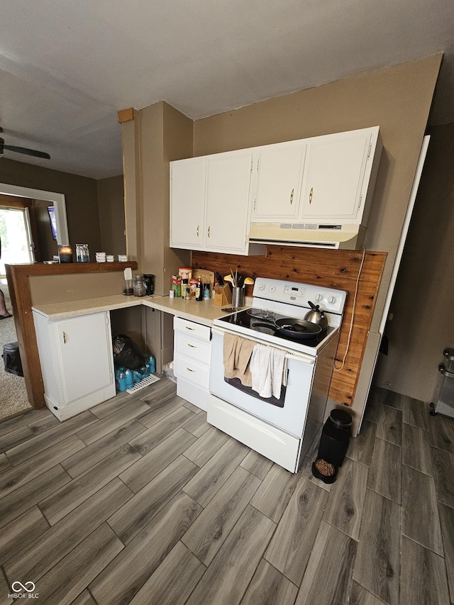 2824 Brown St, Anderson, IN 46016 - kitchen with white electric stove, under cabinet range hood, dark wood finished floors, and white cabinetry