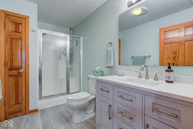 7911 Bentley Commons Dr, Indianapolis, IN 46259 - bathroom with wood finished floors, vanity, a shower stall, and a textured ceiling
