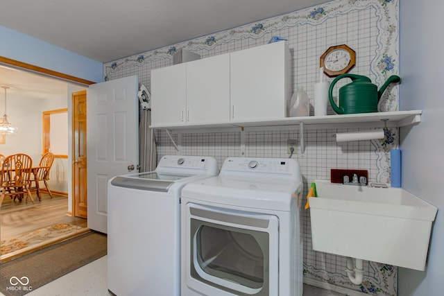 7911 Bentley Commons Dr, Indianapolis, IN 46259 - laundry area featuring washer and dryer, cabinet space, and a chandelier
