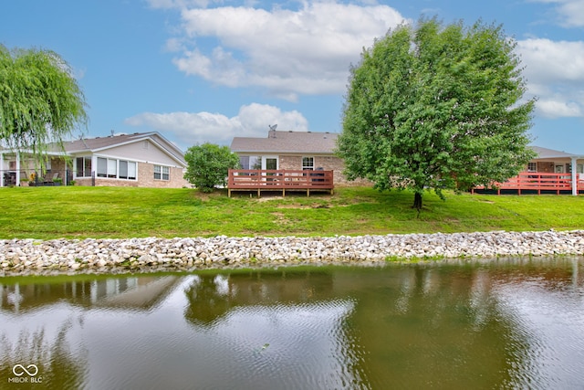 7911 Bentley Commons Dr, Indianapolis, IN 46259 - back of property with a deck with water view, a yard, and brick siding