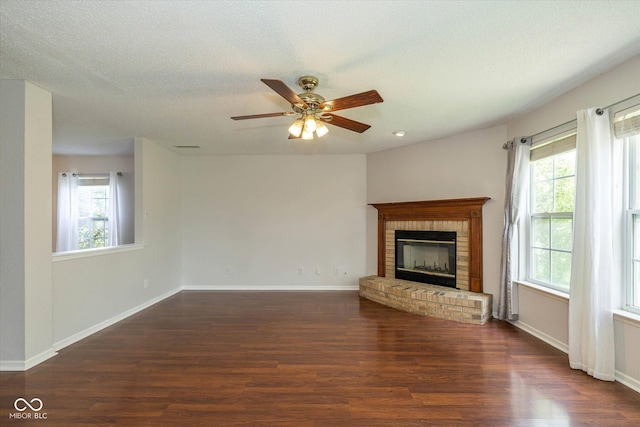 14523 Lee Stewart Ln, Fishers, IN 46038 - unfurnished living room with wood finished floors, plenty of natural light, a brick fireplace, a ceiling fan, and a textured ceiling