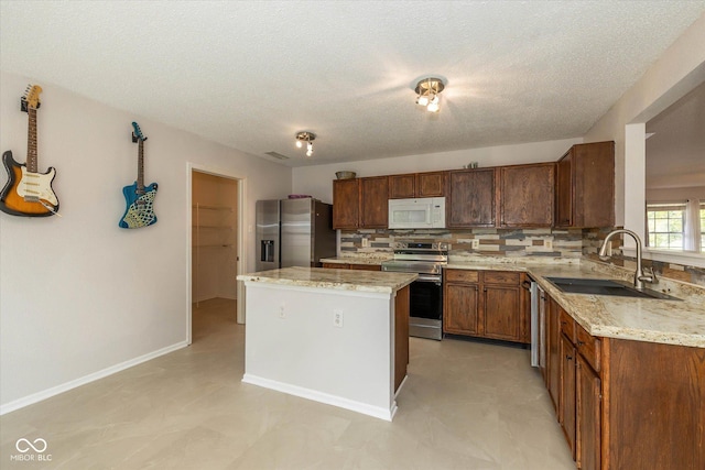 14523 Lee Stewart Ln, Fishers, IN 46038 - kitchen with appliances with stainless steel finishes, tasteful backsplash, a center island, light stone countertops, and a textured ceiling