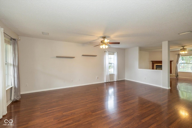 14523 Lee Stewart Ln, Fishers, IN 46038 - unfurnished living room with a ceiling fan, a textured ceiling, dark wood finished floors, and a fireplace