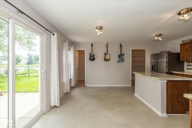 14523 Lee Stewart Ln, Fishers, IN 46038 - kitchen featuring stainless steel fridge with ice dispenser, a center island, a textured ceiling, and light stone countertops