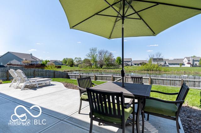 12584 Cold Stream Rd, Noblesville, IN 46060 - fenced backyard featuring a patio area, outdoor dining area, a water view, and a residential view