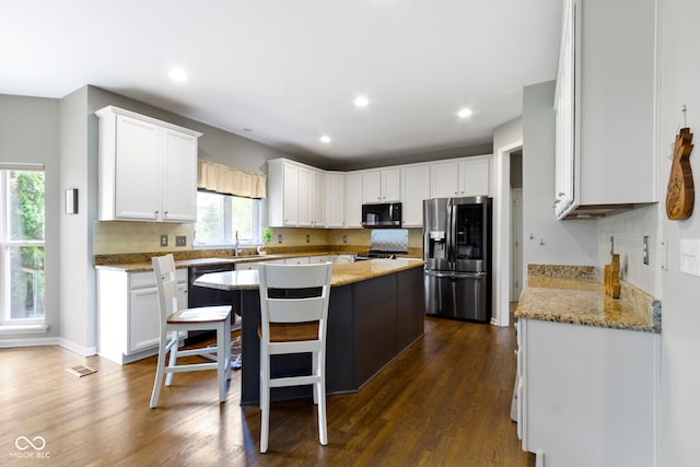 13624 Alston Dr, Fishers, IN 46037 - kitchen featuring stainless steel fridge, black microwave, a center island, white cabinets, and dark wood finished floors