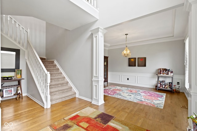 13624 Alston Dr, Fishers, IN 46037 - foyer entrance with decorative columns, stairs, wood finished floors, ornamental molding, and a wainscoted wall