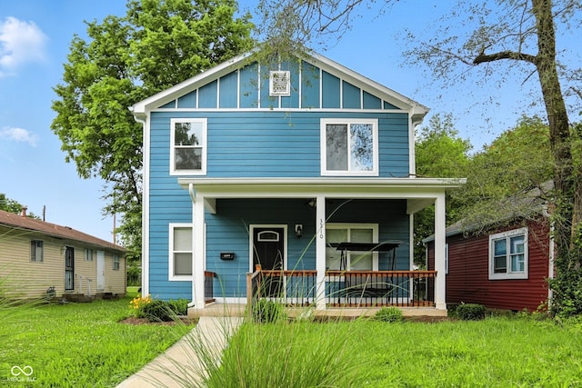 3210 Hovey St, Indianapolis, IN 46218 - view of front facade with covered porch, board and batten siding, and a front lawn