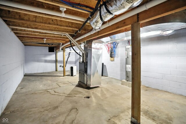 3210 Hovey St, Indianapolis, IN 46218 - unfinished basement with water heater, heating unit, and concrete block wall
