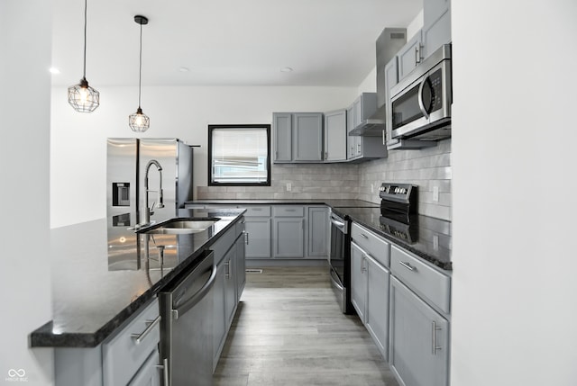 3210 Hovey St, Indianapolis, IN 46218 - kitchen featuring stainless steel appliances, gray cabinets, dark stone counters, and tasteful backsplash