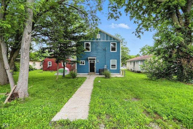 3210 Hovey St, Indianapolis, IN 46218 - townhome / multi-family property with a front lawn and board and batten siding