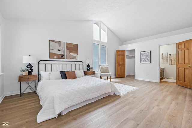 5982 Oak Hill E Dr, Plainfield, IN 46168 - bedroom with light wood-style floors, a closet, connected bathroom, high vaulted ceiling, and a spacious closet