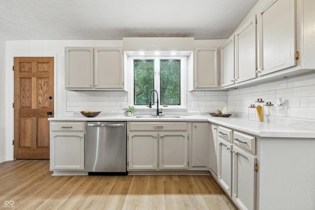 5982 Oak Hill E Dr, Plainfield, IN 46168 - kitchen featuring stainless steel dishwasher, decorative backsplash, light wood-type flooring, a textured ceiling, and light countertops