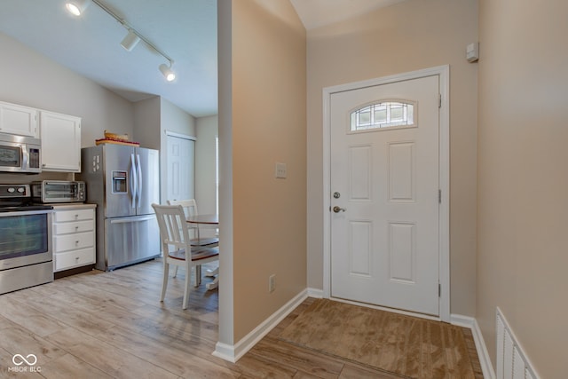 741 Chestnut Ln, Brownsburg, IN 46112 - foyer entrance with light wood-style floors, lofted ceiling, and track lighting