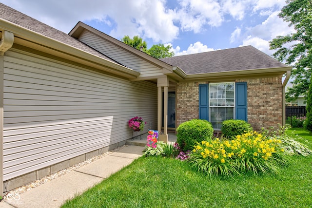 741 Chestnut Ln, Brownsburg, IN 46112 - doorway to property featuring brick siding, roof with shingles, and a yard