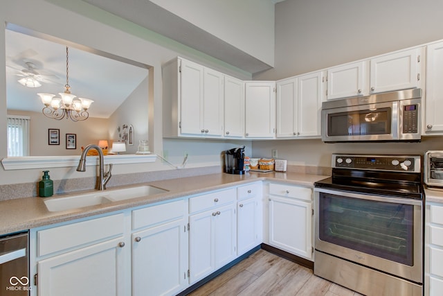 741 Chestnut Ln, Brownsburg, IN 46112 - kitchen featuring stainless steel appliances, light countertops, white cabinetry, a chandelier, and lofted ceiling