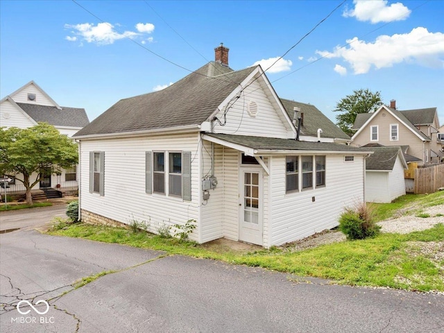 215 N E St, Greensburg, IN 47240 - view of home's exterior featuring a chimney and roof with shingles