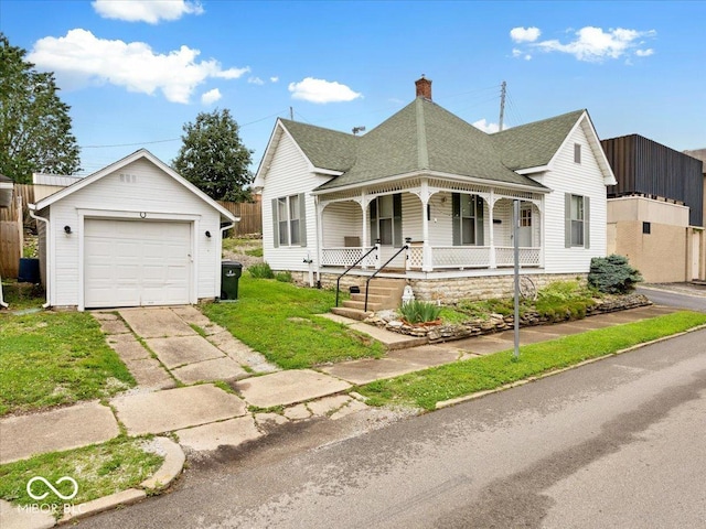 215 N E St, Greensburg, IN 47240 - victorian-style house with an outdoor structure, covered porch, a detached garage, a chimney, and driveway