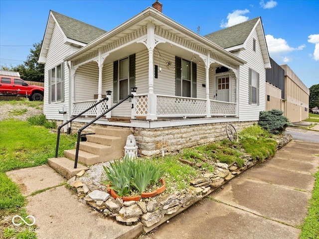 215 N E St, Greensburg, IN 47240 - view of front of house featuring covered porch, a shingled roof, and a chimney