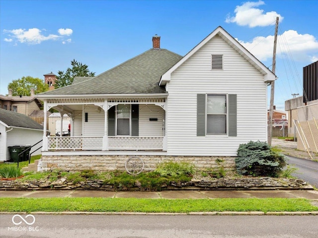 215 N E St, Greensburg, IN 47240 - view of front of home featuring a porch, roof with shingles, and a chimney